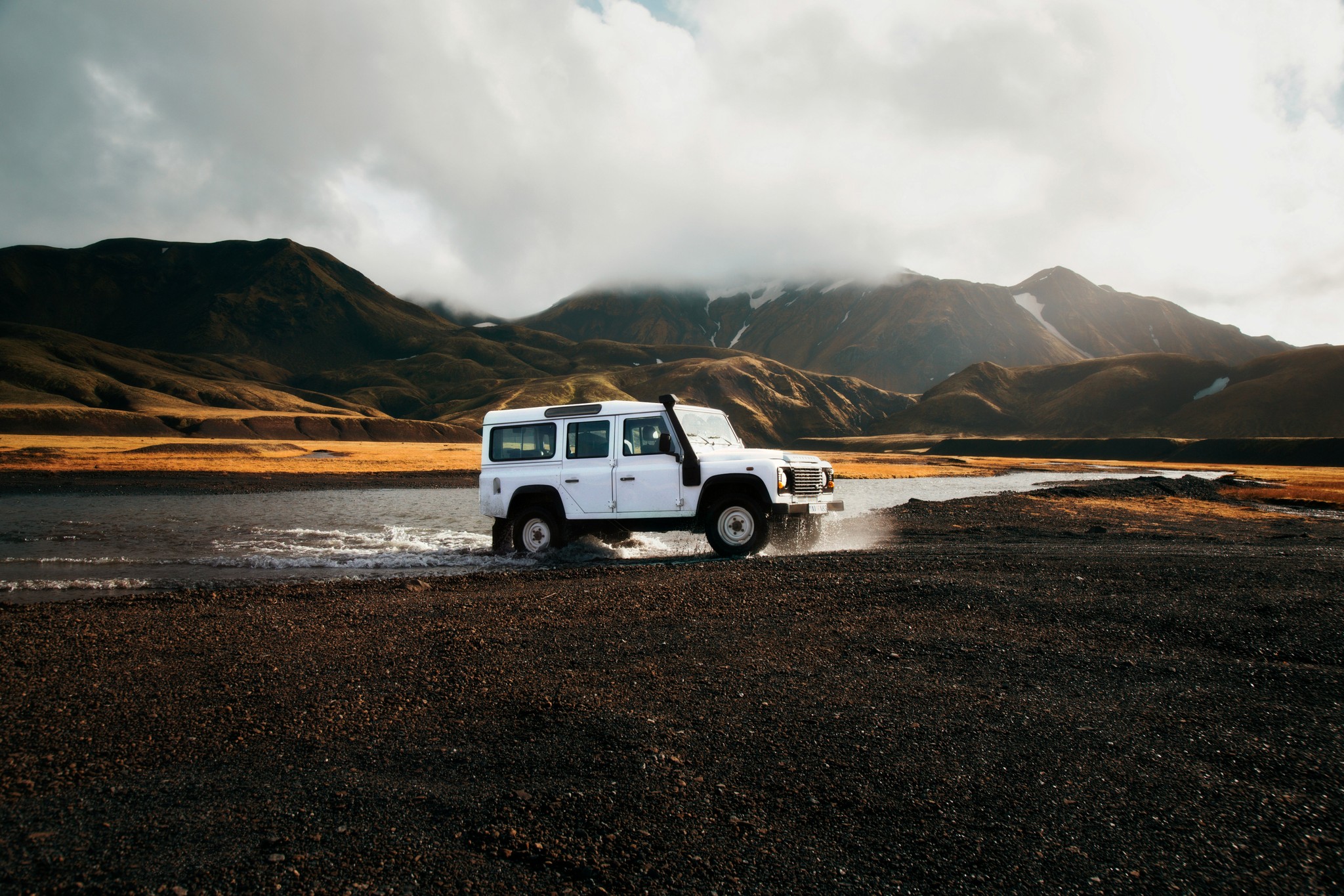 A 4x4 vehicle crossing a river in Iceland.