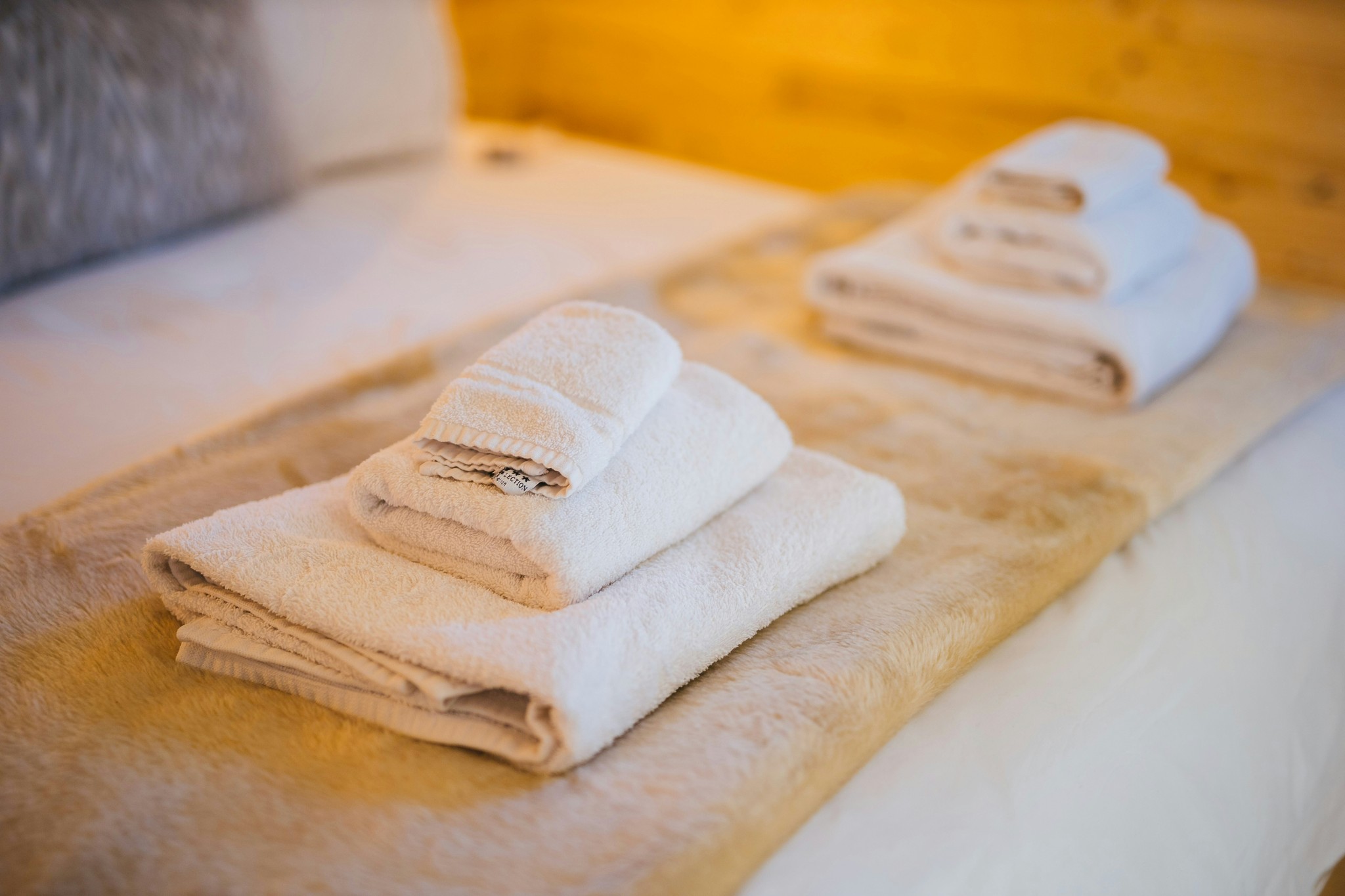 Freshly folded towels arranged on a hotel bed.