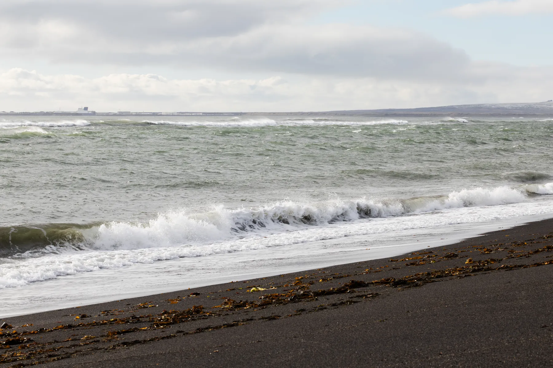 Waves breaking on the black sand beach at Óseyrartangi